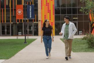two students in front of utsa flags